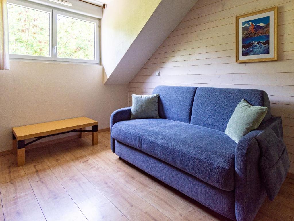 a living room with a blue couch and a table at Les Chalets d Ax N 303 - 2P4C in Ax-les-Thermes