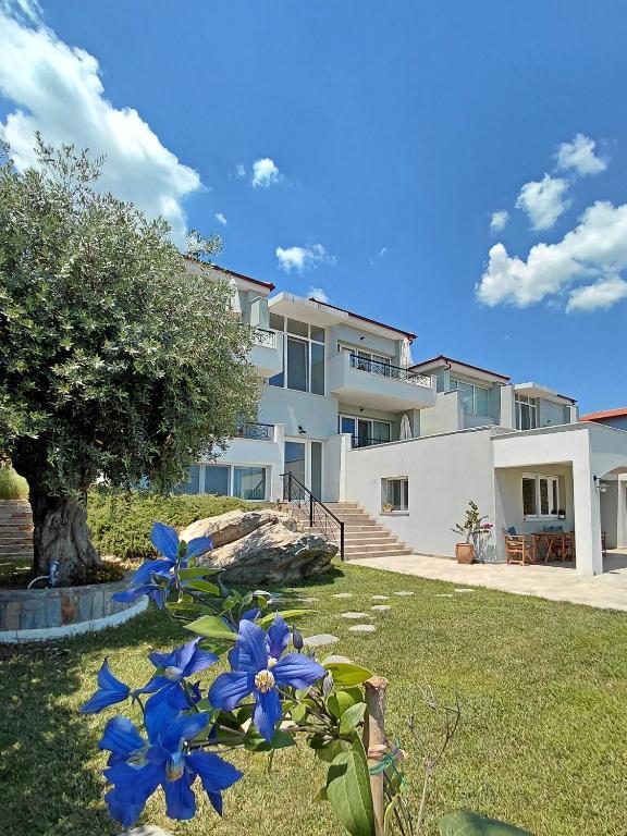 a building with blue flowers in a yard at 7 Grapes in Elevtheraí