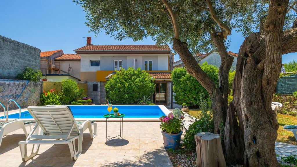 a patio with a table and chairs next to a pool at Villa Rossy by Villas Guide in Pavicini