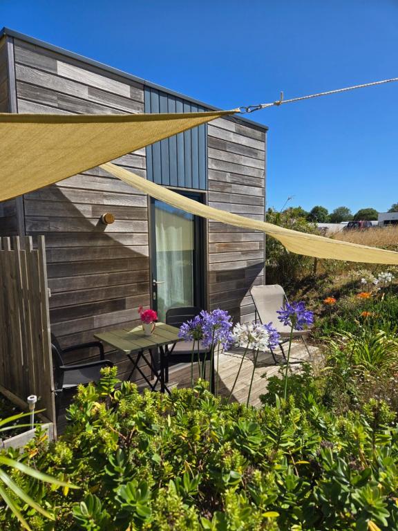 a patio with a table and chairs in front of a house at Chambre privée proche plages in Plozévet