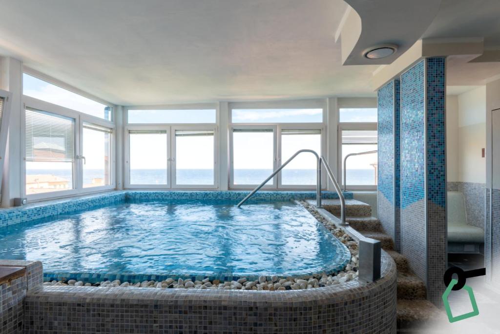 a large swimming pool in a room with windows at HOTIDAY Room Collection - Alassio Centro in Alassio