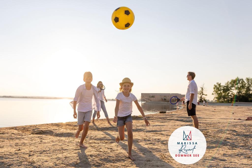 a group of people playing with a ball on the beach at Marissa Resort in Lembruch