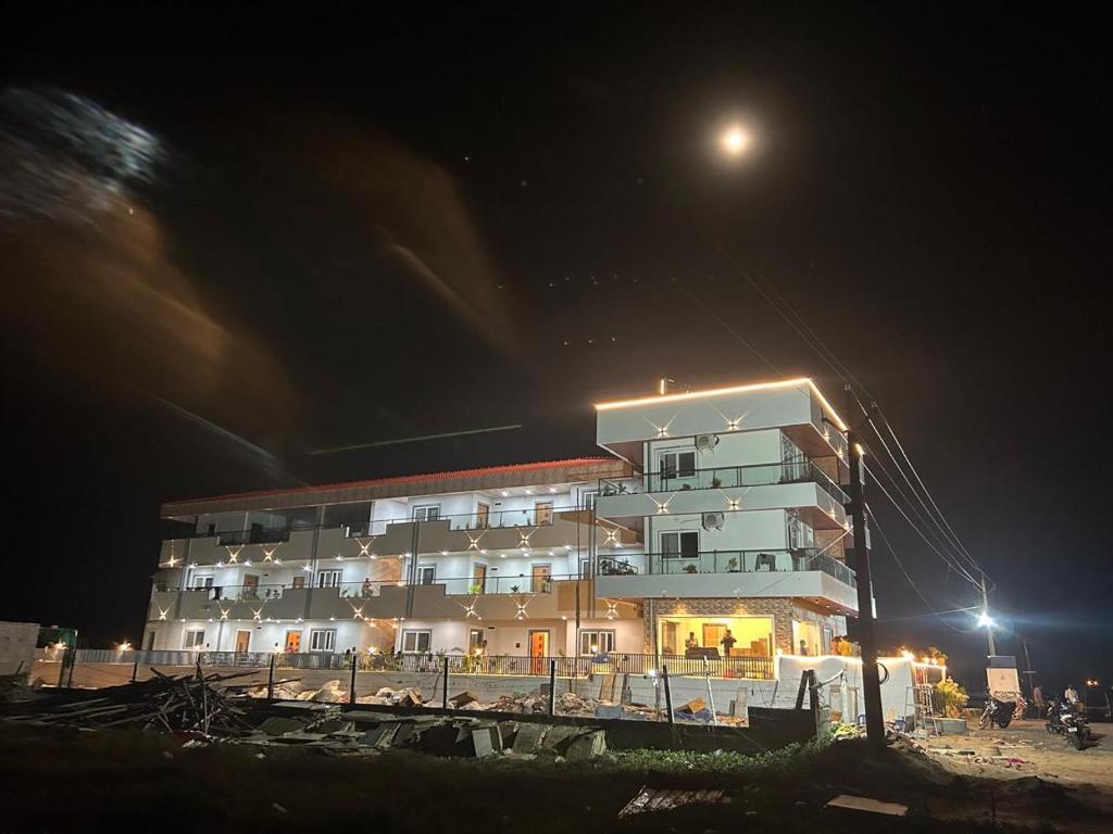 a large building at night with the moon behind it at S R RESORTS in Chīrāla