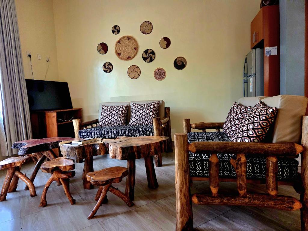 a living room filled with wooden tables and chairs at Akagera Sunset House in Kabarondo
