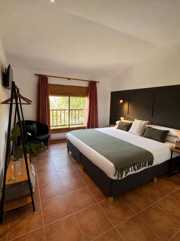 a bedroom with a large bed and a window at Hotel Casa Eira B&B in La Molina