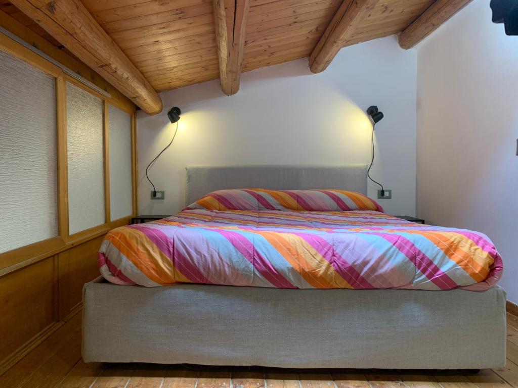 a bedroom with a bed with a colorful comforter at Casa Mao in Noto