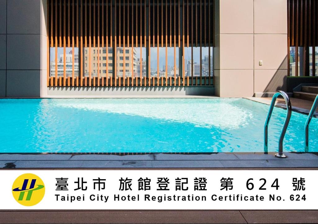 a large swimming pool in a building with a sign at Caesar Metro Taipei in Taipei