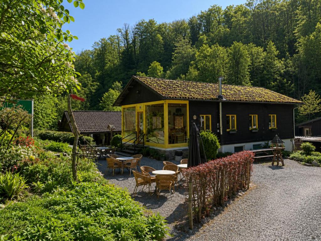 a house with a table and chairs in a garden at Camping La Lienne in Stoumont