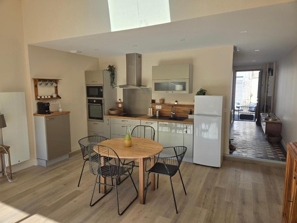 a kitchen with a table and chairs and a kitchen with white appliances at Chez mamie in La Rochelle