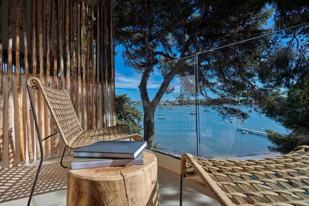 a stack of books sitting on a chair on a porch at Barefoot Hotel Mallorca in Portocolom