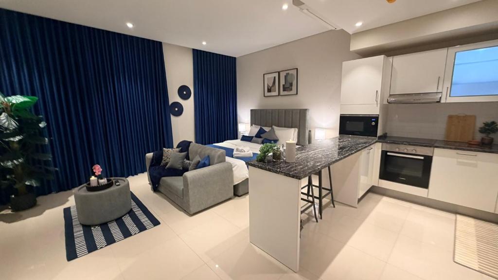 a kitchen and living room with a couch and a table at Navy Studio By Bait Zain in As Sīfah