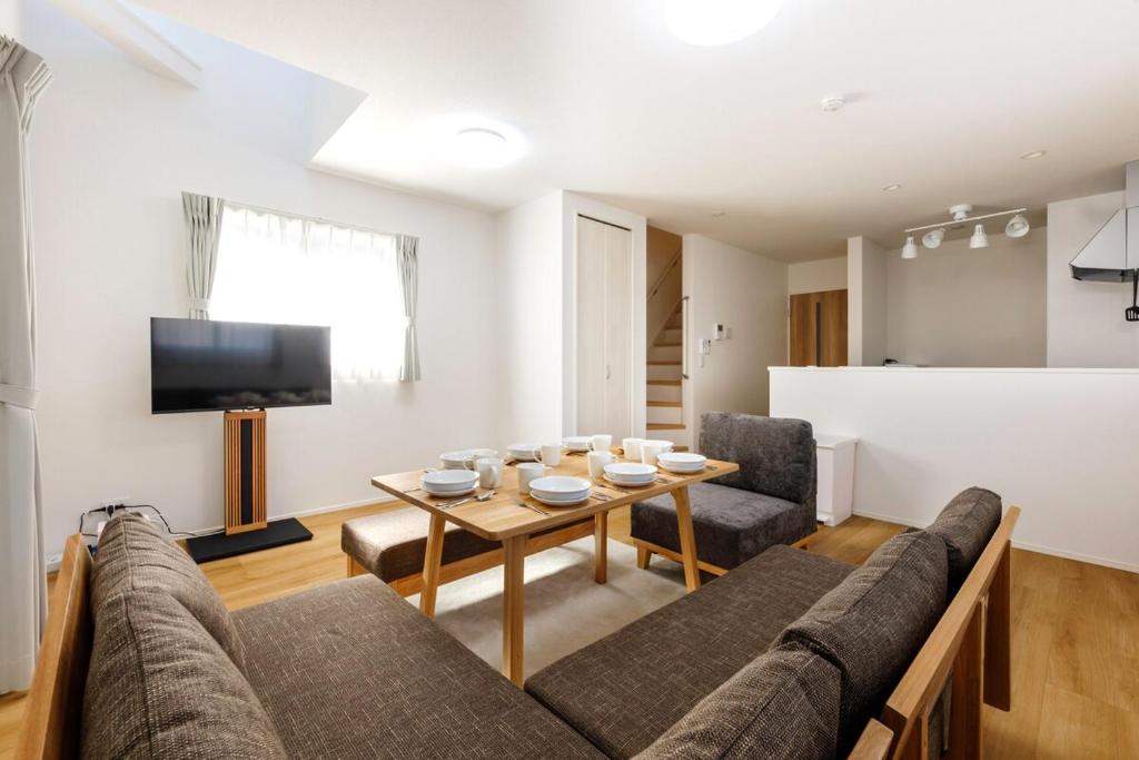 a living room with a couch and a table at Asobi Stay大日 山吹 in Nagoya