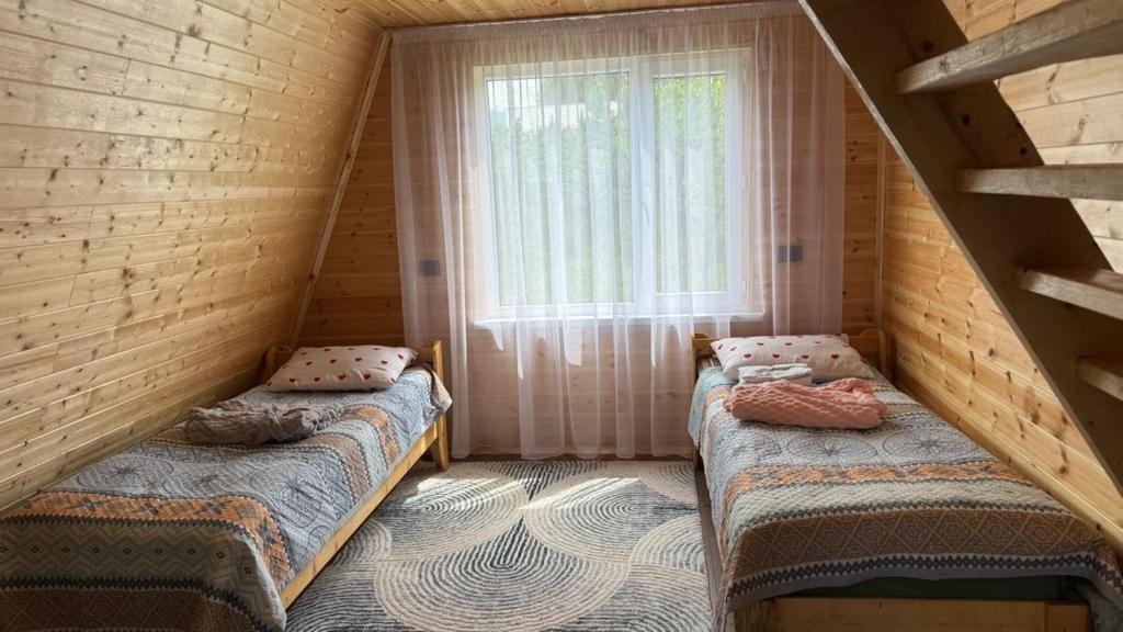 two beds in a room with a window at JEEK A-Frame in Tong