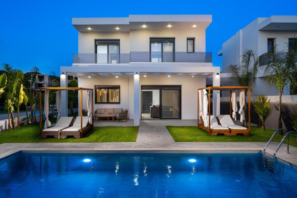 a villa with a swimming pool in front of a house at Villa Elesia in Kremasti