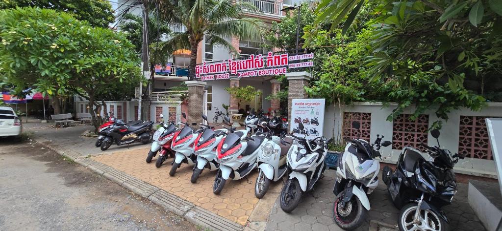 a row of scooters parked in front of a building at Khmer House Kampot Boutique in Kampot