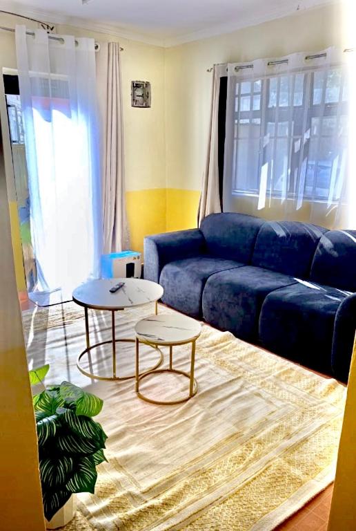 a living room with a blue couch and a table at Tranquil stays in Bungoma