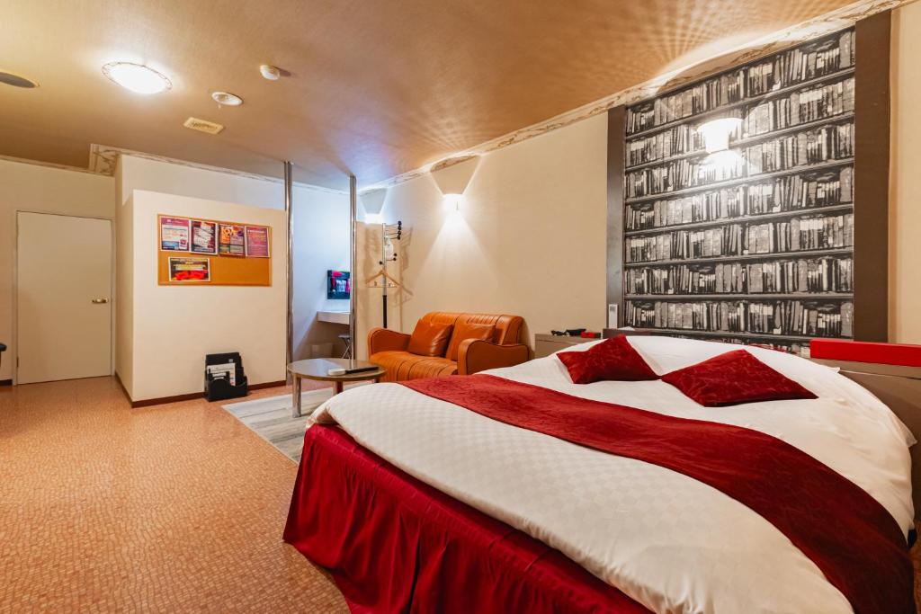 a bedroom with a large bed and a chair at Earn Exception in Isesaki