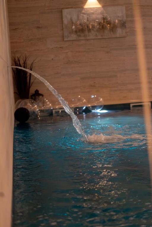 a person is spraying water into a swimming pool at Moj Hir Boutique Rooms & Wellness Spa in Jastrebarsko