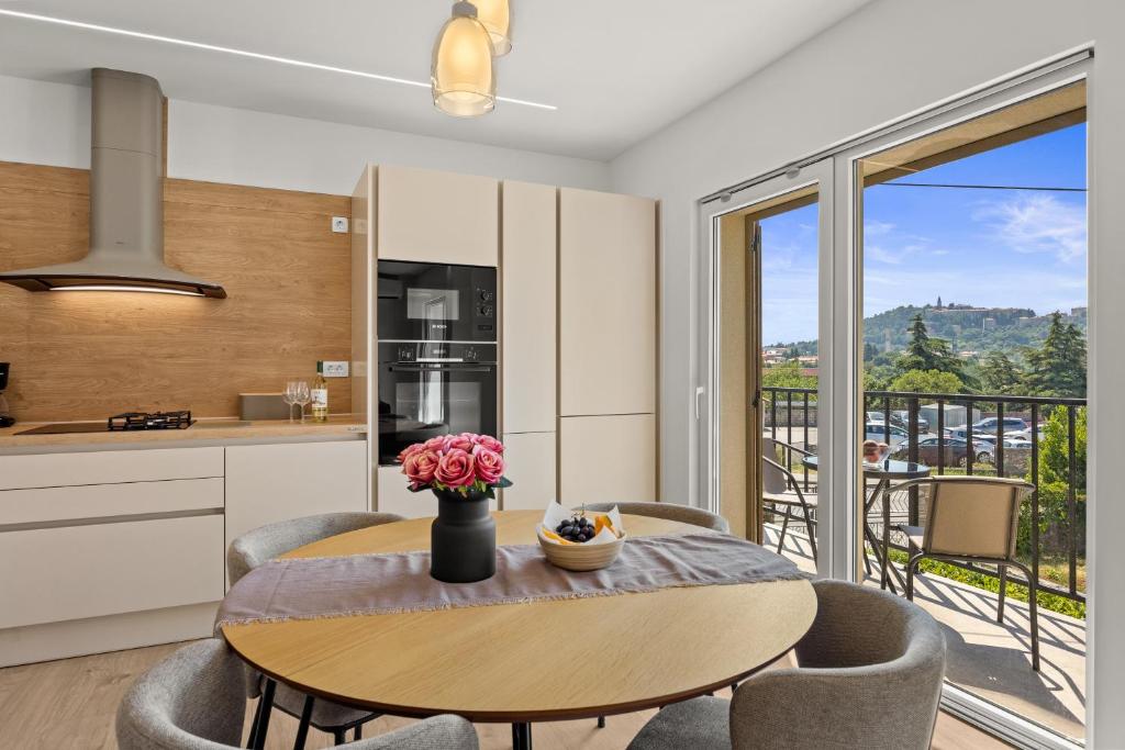 a kitchen and dining room with a table and a balcony at Danijela Holiday Home in Labin