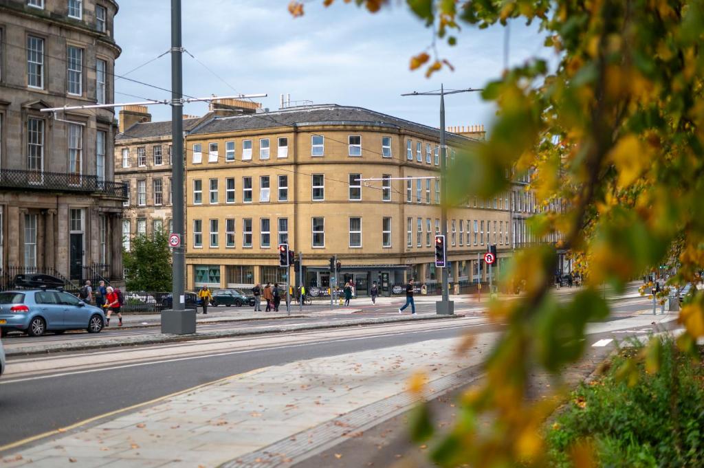 a city street with buildings and a road with cars at Edinburgh Central Accommodation in Edinburgh