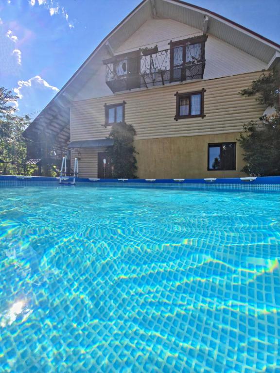 a house with a swimming pool in front of a house at U Nazara in Slavske