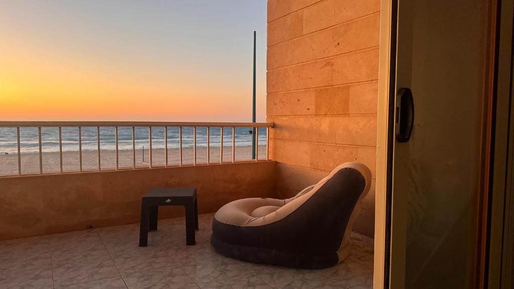 a chair in a room with a view of the ocean at Beachfront Villa Sea View First Row in Dawwār ‘Abd Allāh