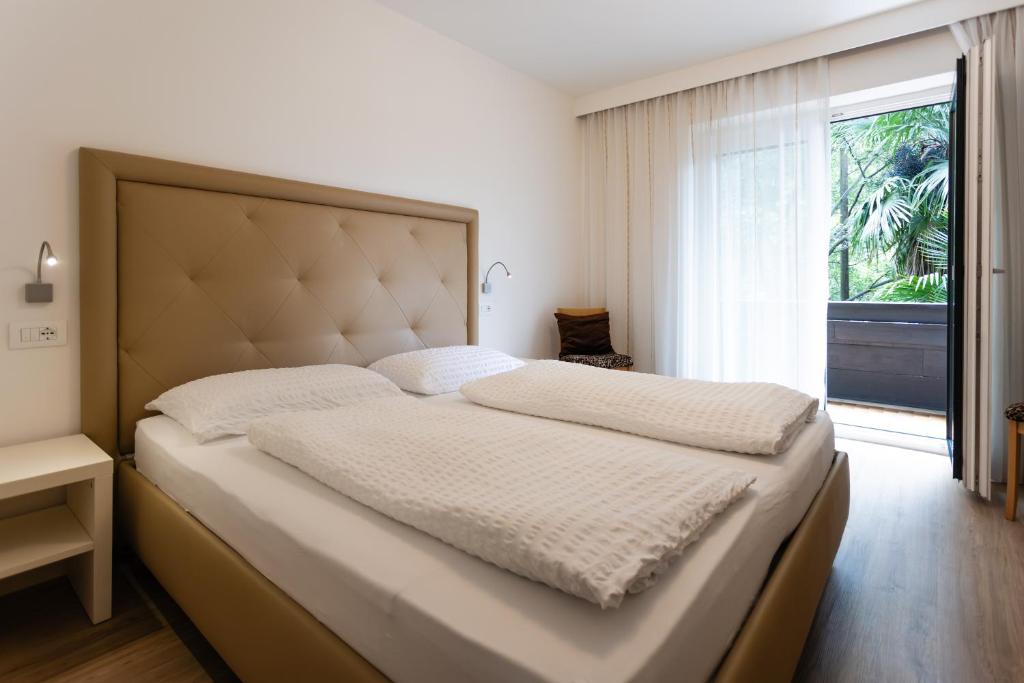 a bedroom with a large bed with a large window at Pension Martha in Postal