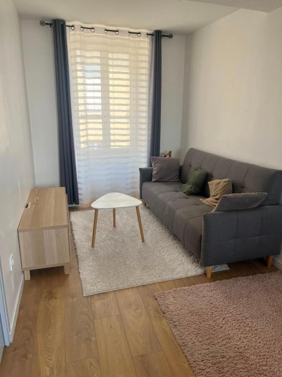 a living room with a couch and a table at T3 proche musées et panorama in Château-Chinon