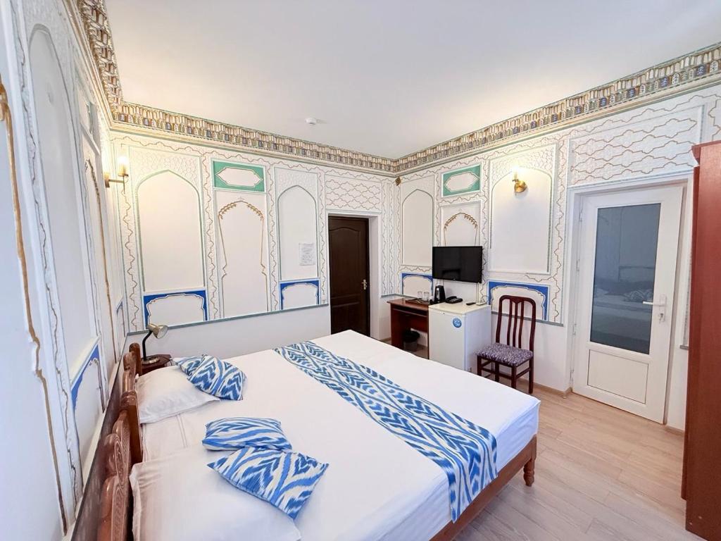 a bedroom with a bed and a desk in it at Ismat Premium Guest House in Bukhara