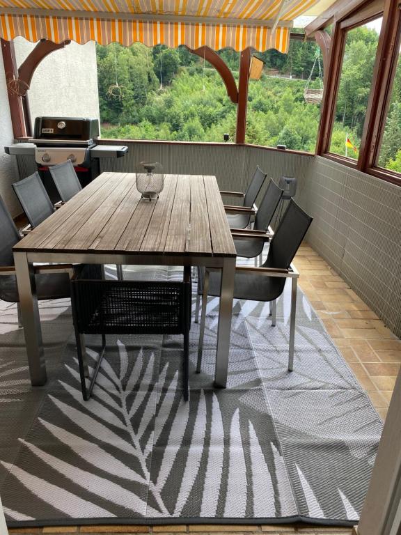 a dining room with a wooden table and chairs at Ferienwohnung Weitblick in Rodalben