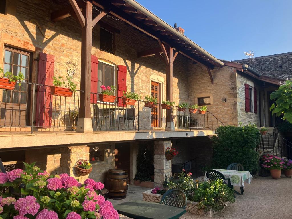 a building with flowers and a balcony with a table and chairs at LA PASSIFLORE in Azé