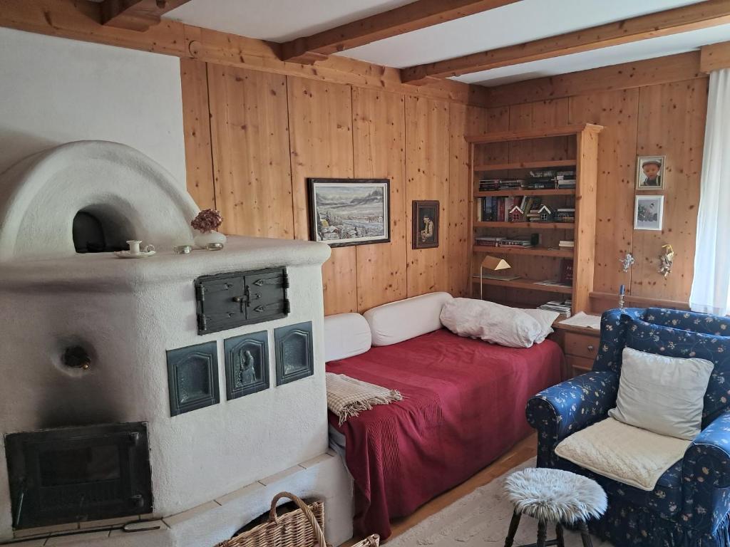 a room with a fireplace and a bed and a chair at Bergblick in Schwaz