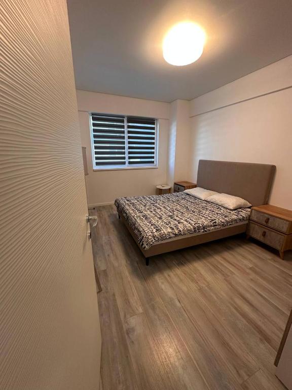 a bedroom with a bed and a window and a door at Two-room apartment in Dudu