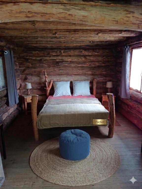 a bedroom with a bed in a log cabin at Le nid de bois insolite in Haget