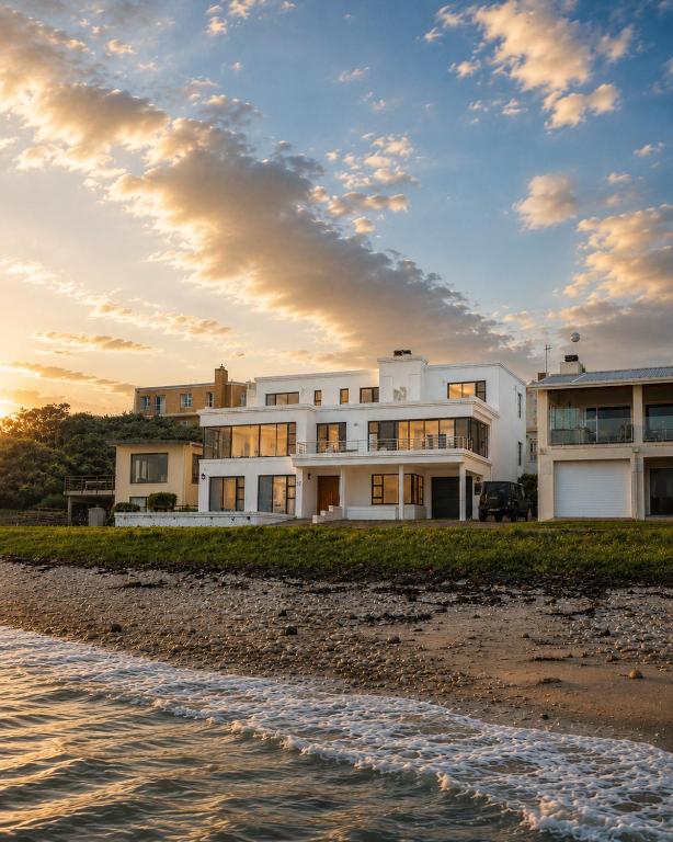 a building on the beach next to the water at High Tide Seafront at Franskraal in Franskraalstrand
