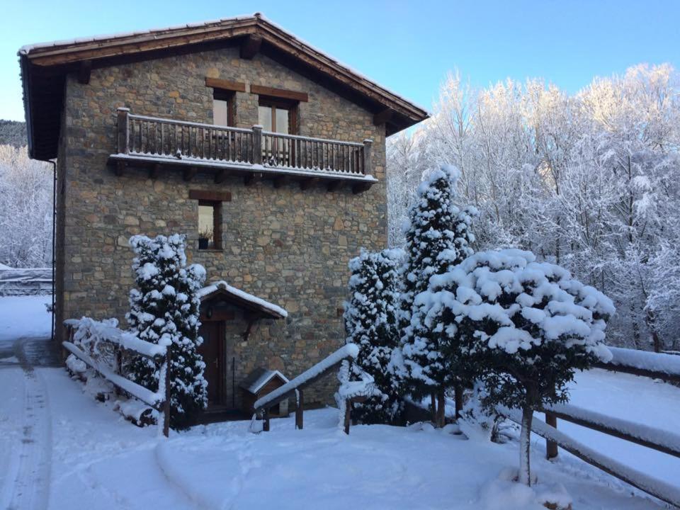 a brick building with a balcony in the snow at Els Torrents in Bellver de Cerdanya