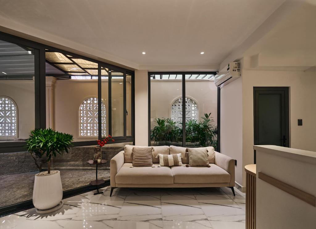 a living room with a couch and some windows at Luckin Hotel Lê Đức Thọ by Urban B in Ho Chi Minh City