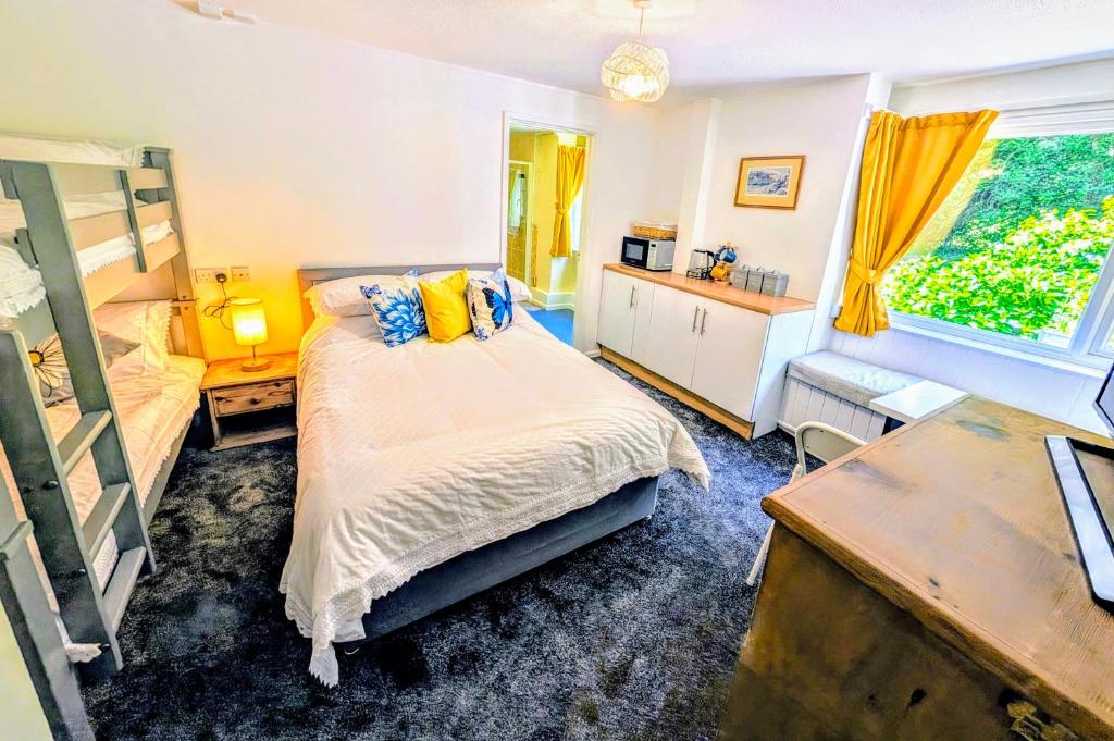 a bedroom with a bed and a desk and a window at Parkside Lodge Hotel in Camelford