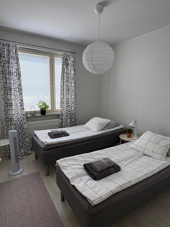 a bedroom with two beds and a large window at Harju Apartment in Jyväskylä