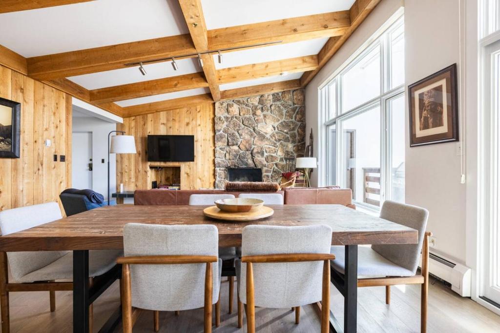 a dining room with a wooden table and chairs at Mountainside Top Floor Condo - Treetops Lionshead in Vail