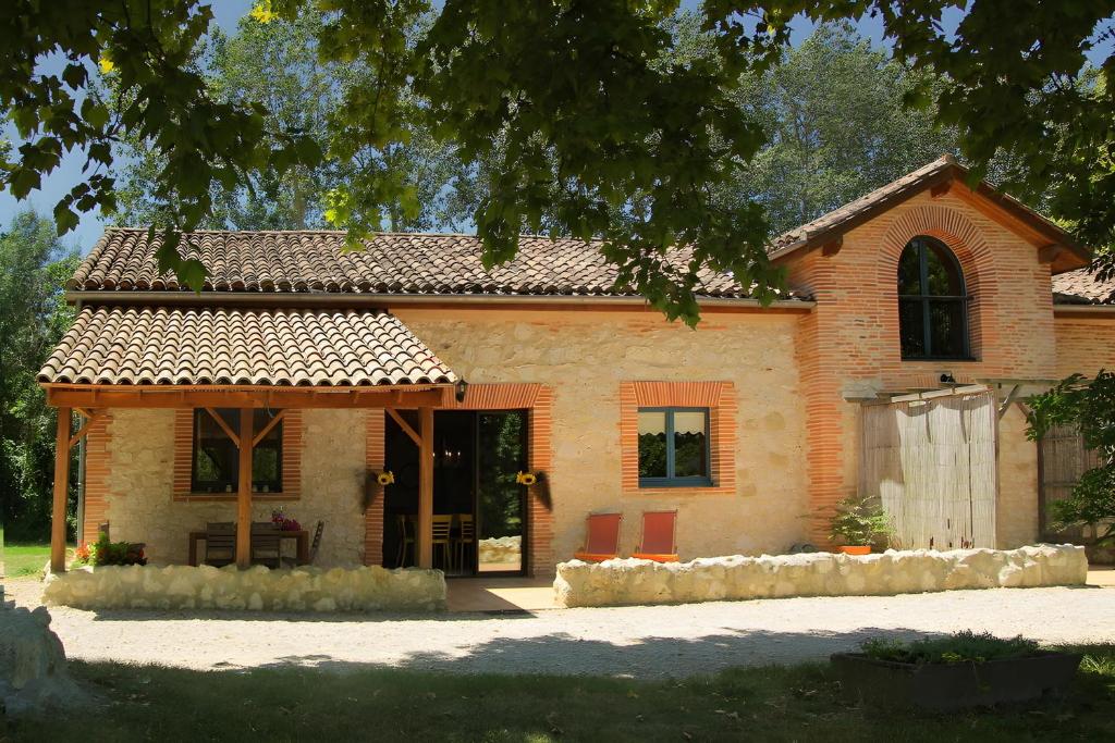 a large brick house with a large window at Domaine du Roujos - Gite Ocre in Beaumont-de-Lomagne