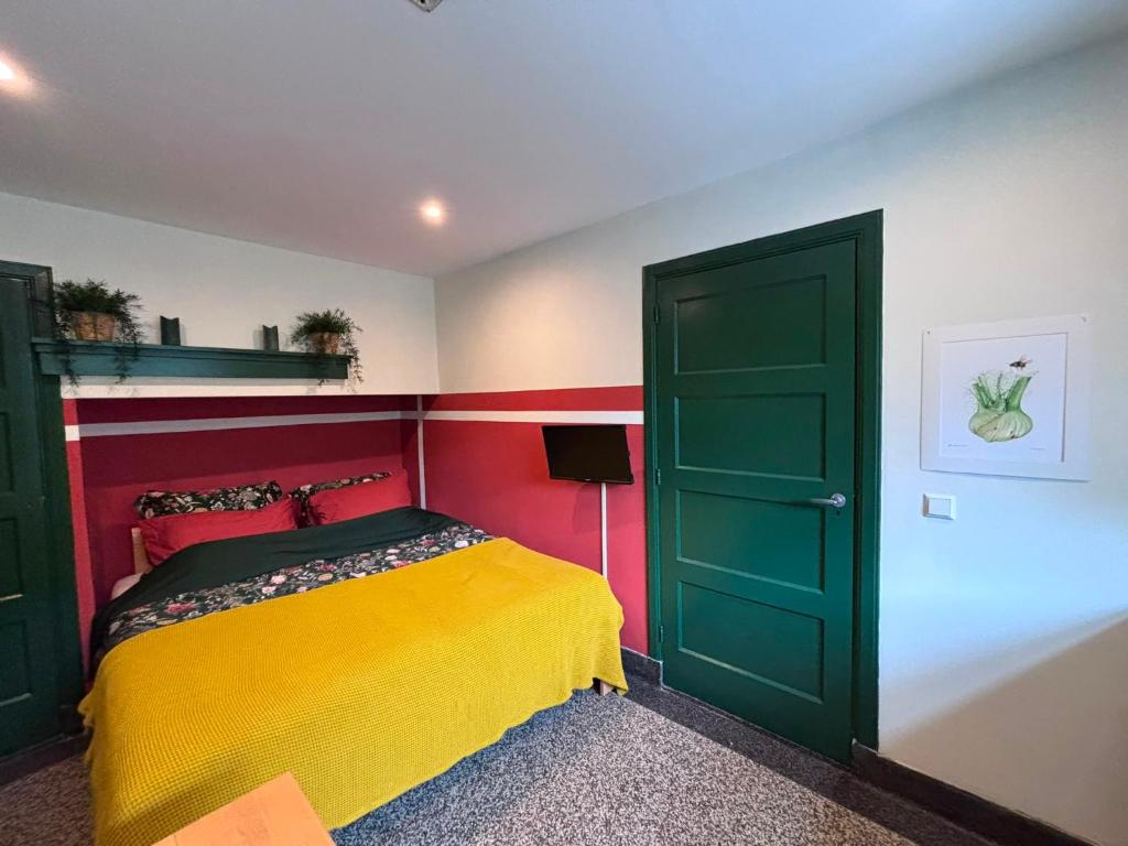 a bedroom with a green door and a yellow bed at Morgenstond in Groesbeek
