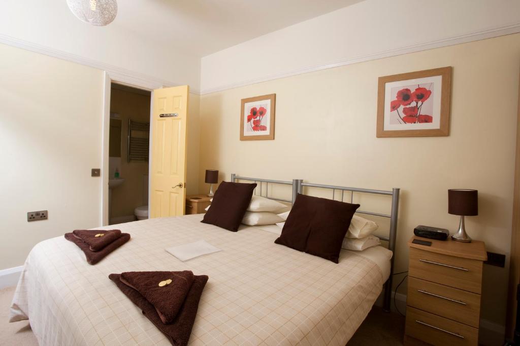 a bedroom with a large white bed with brown pillows at Cranston House in East Grinstead