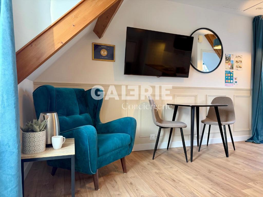 a living room with a blue chair and a table at GC - Au Gré Du Vent in Wissant