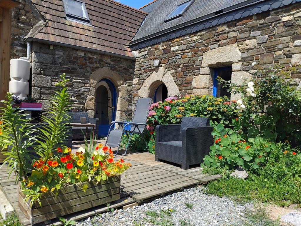 a patio with chairs and flowers in front of a building at Gîte De L'alliance in Lannion