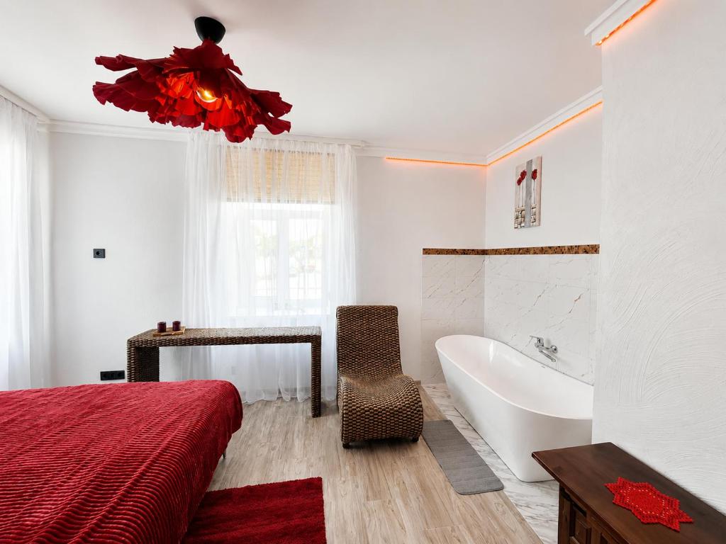 a bedroom with a bed and a tub and a sink at Oāze Aucē in Auce