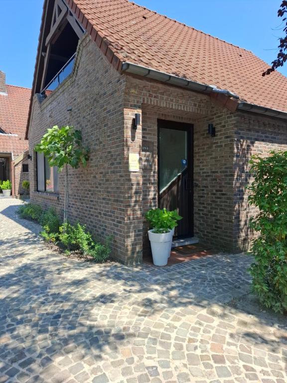 a brick building with a door and a porch at Pieters Huis in Kinrooi