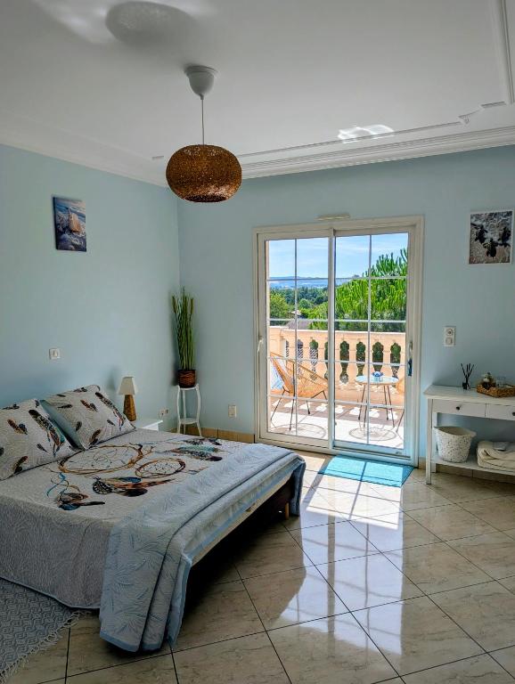 a bedroom with a bed and a view of a patio at Jardhelena in Jardin