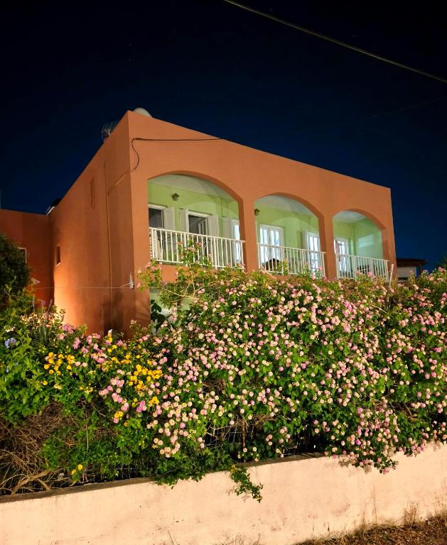 a building with a bunch of flowers in front of it at Livadi Apartments in Plakias