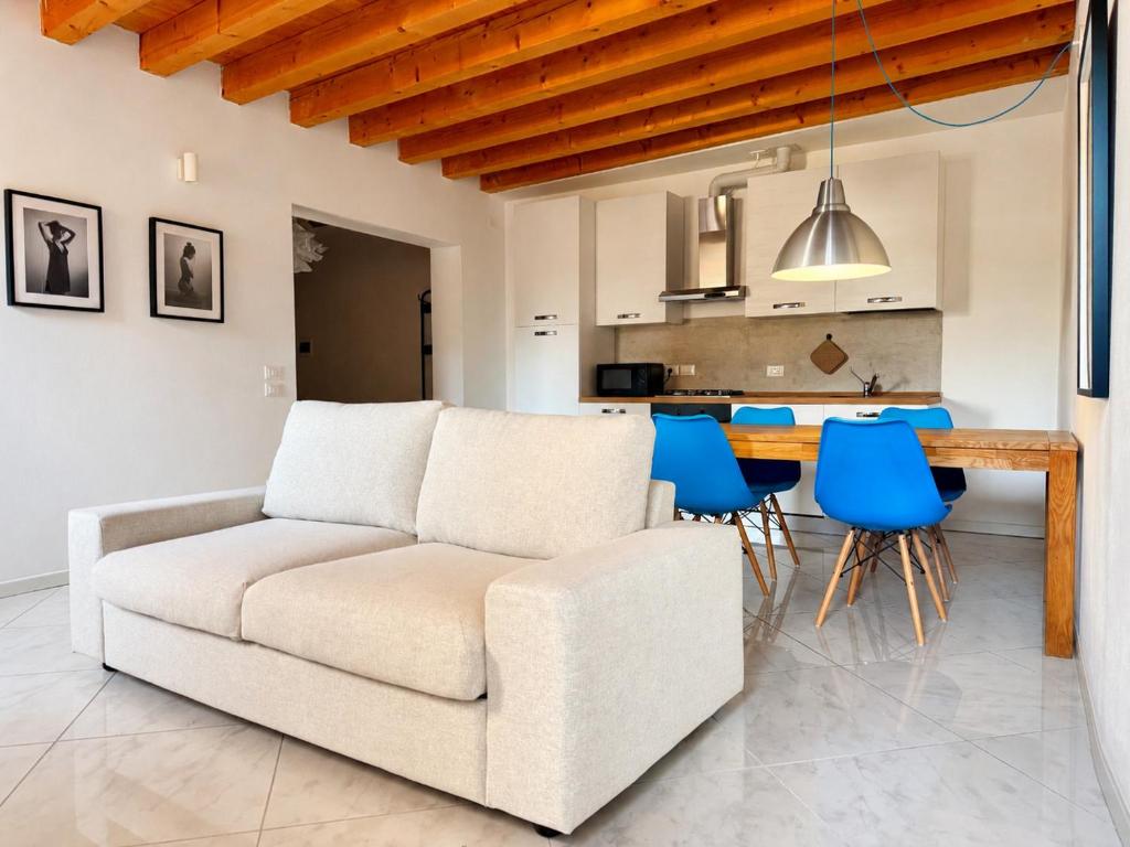 a living room with a white couch and blue chairs at Appartamento Donà 2 in Rovigo